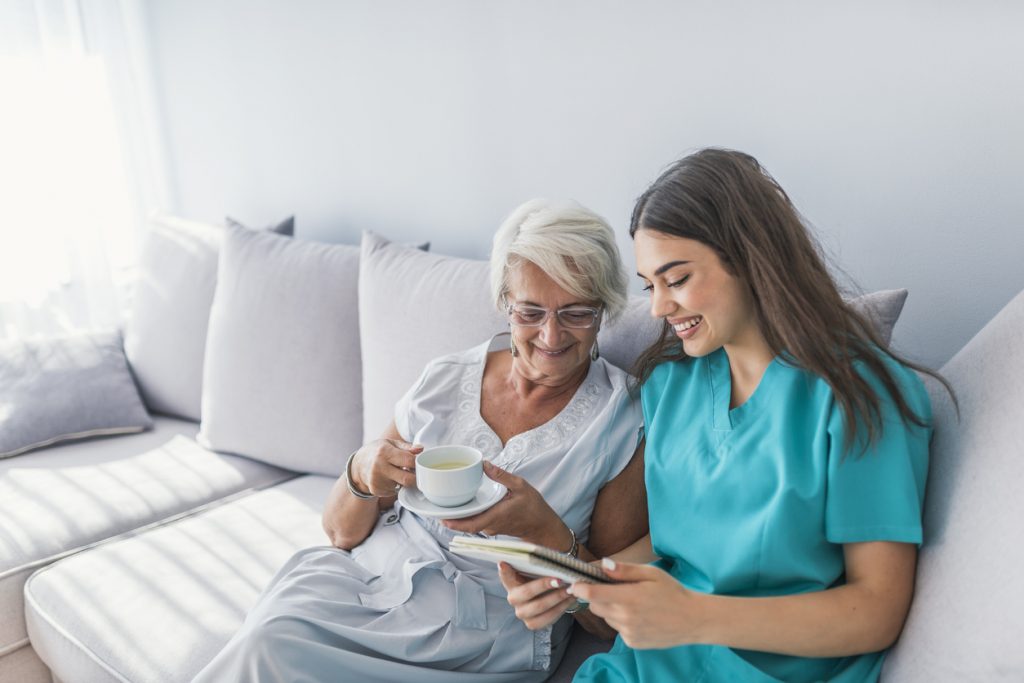 Caregiver reading with an elderly patient