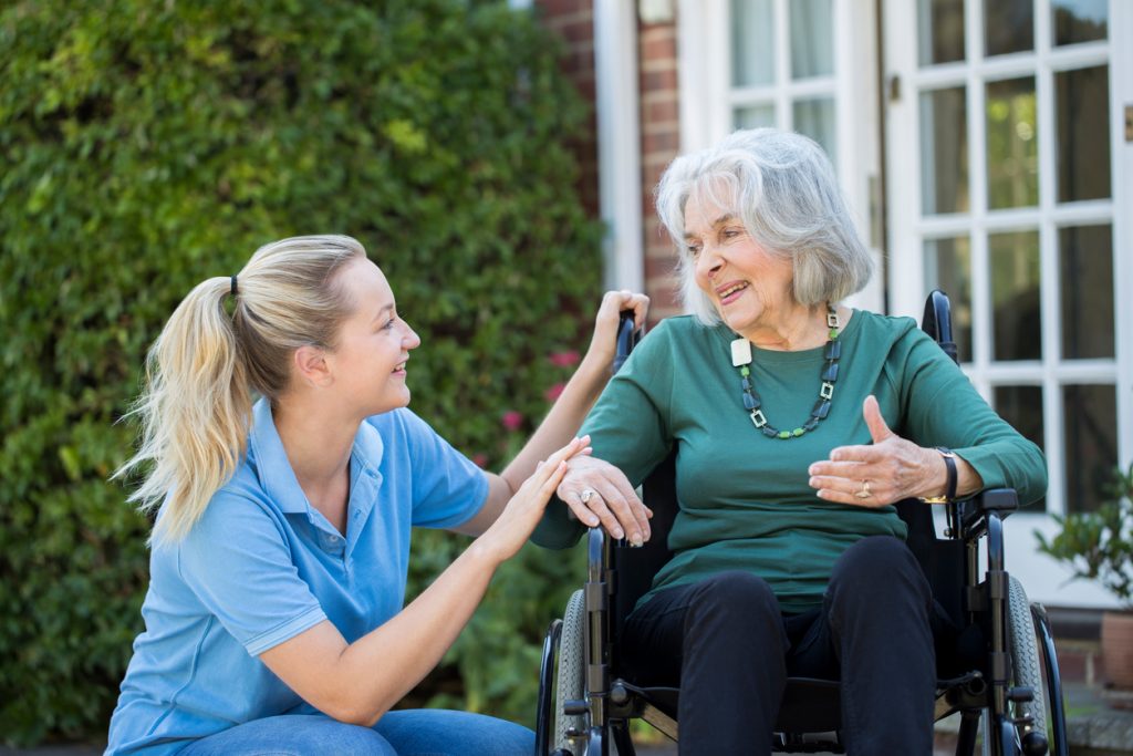 Caregiver assisting senior lady in wheelchair