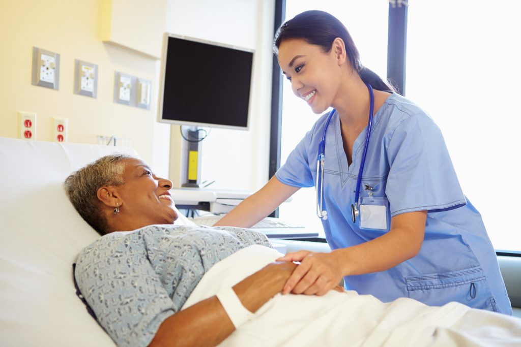 Nurse tending to a patient in a hospital bed