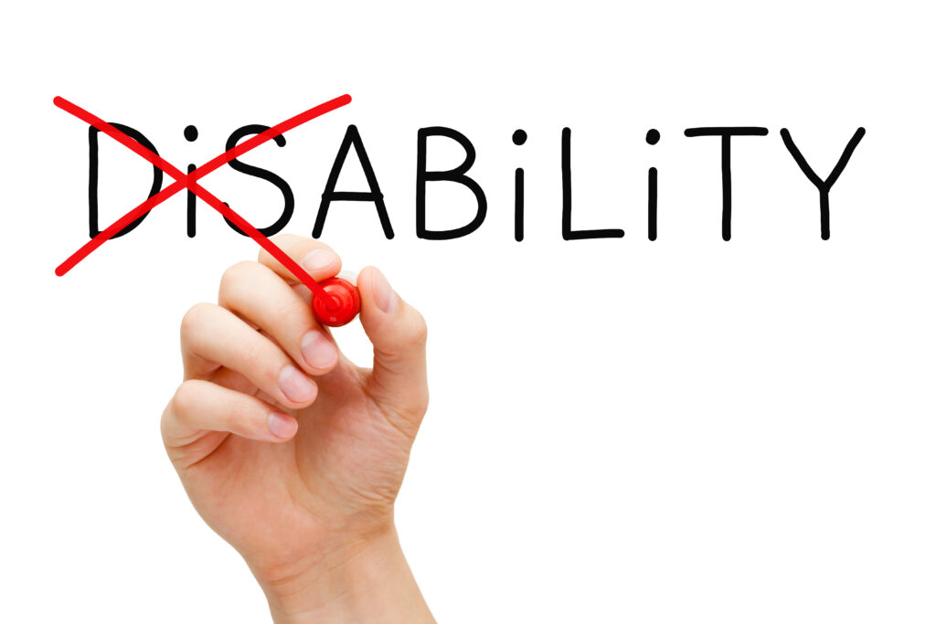 Hand crossing out dis from disability